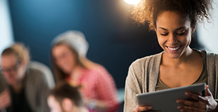 Woman looking at tablet with family in the background