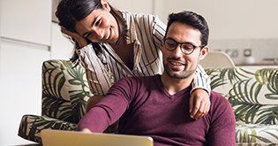 Couple laughing looking at laptop